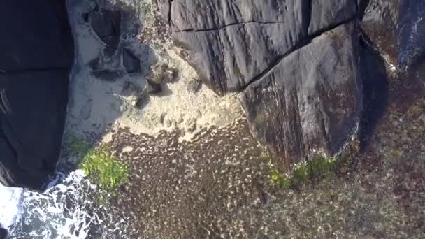 Hölgy fekete fekszik a nagy sziklás szikla körül óceán — Stock videók
