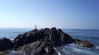 sonsuz okyanusta kayalık uçurumun tepesinde bayan siluet dansları