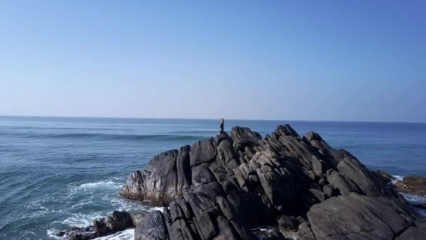 Silhouette dame médite dans la pose de yoga sur le sommet de la falaise aux vagues — Video