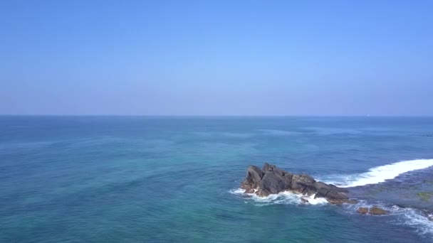 महिला अंतहीन नीले महासागर में बड़े चट्टान चट्टान पर ध्यान देती है — स्टॉक वीडियो
