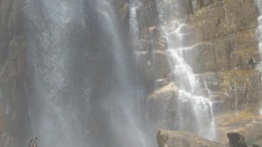 beyaz köpüklü tatlı su ıslak kahverengi kayalara düşer.