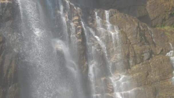 blanc moussant l'eau douce tombe sur les roches brunes humides 
