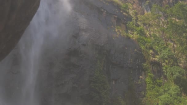 cascade à la falaise rocheuse sous la lumière du soleil d'été lumineux 