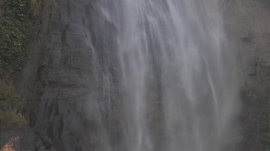 Kayalık uçurumdan yeşil çimenli beyaz köpüklü şelale.