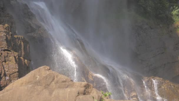 Cascade mousseuse blanche de falaise rocheuse avec herbe verte — Video