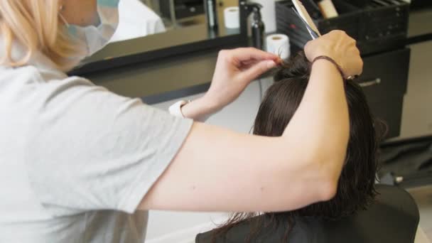 Profissional cabeleireiro torce solto fio escuro na cabeça — Vídeo de Stock