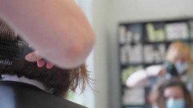 Kuaför elinde özel tarak tutarak modern saç kesimini tamamladı