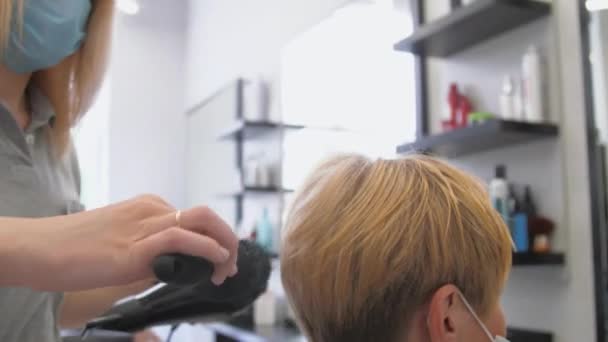 Peluquería especializada trabaja y realiza peinado moderno — Vídeos de Stock