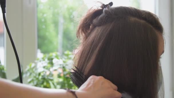Stylista ręce trzymać suszarkę i grzebień podejmowania nowoczesnej fryzury — Wideo stockowe