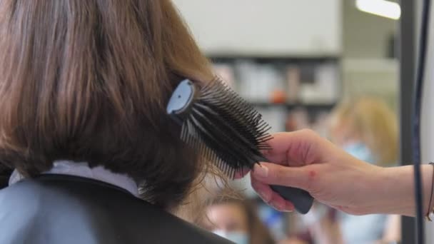 Skilled lady hands hold dryer drying short dark hair strand — Stock Video