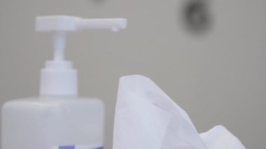 Beyaz plastik şişe ve kuru mendillerin yanında tıbbi dezenfektan.
