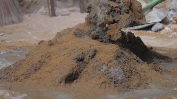 Voda padá na betonovou hromadu se žlutým pískem před smícháním — Stock video