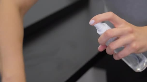 Lady hand holds transparent bottle and sprays sanitizer — Stock Video