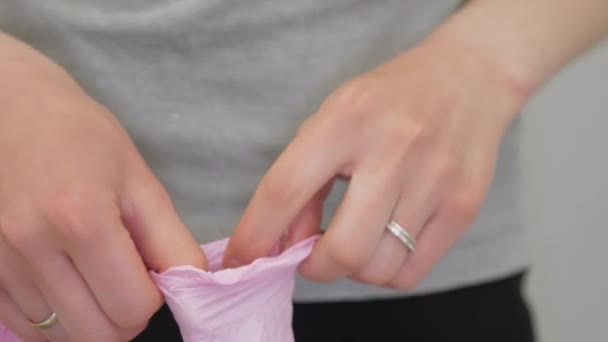 Τρυφερά χέρια γυναίκας φορούν ειδικά ιατρικά ροζ αποστειρωμένα γάντια — Αρχείο Βίντεο