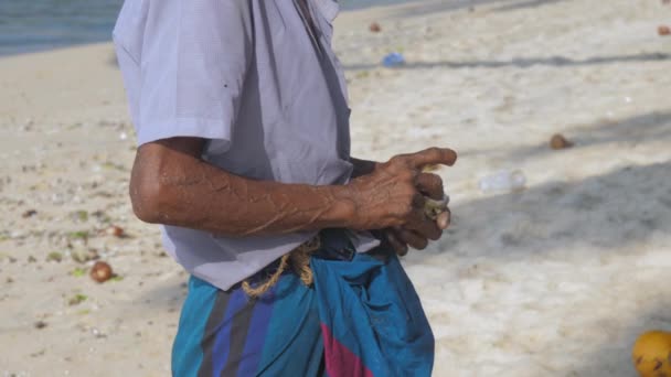 Localnicul ține tija de pescuit în mână împotriva fluturând oceanul — Videoclip de stoc