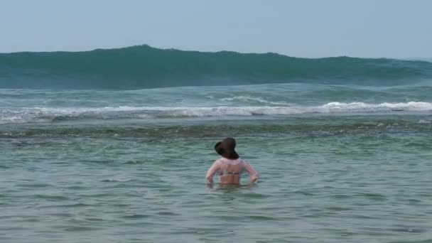Mladá dáma v zeleném klobouku stojí uprostřed tropického oceánu — Stock video