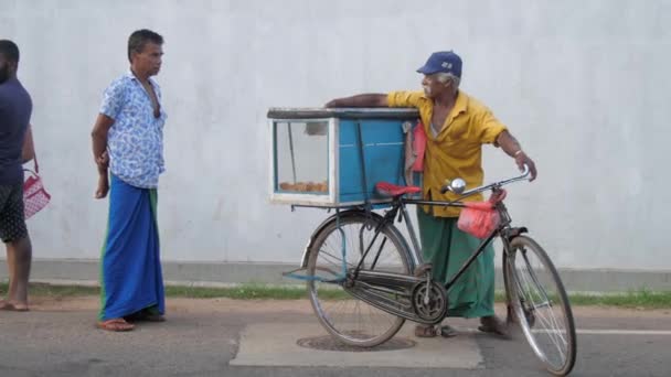 Місцевий чоловік тримає пластикову коробку і ходить зі старим велосипедом. — стокове відео