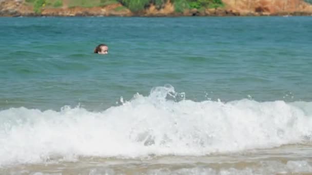 Kvinna med hår bulle njuter av att bada i ljusa tropiska havet — Stockvideo
