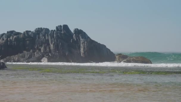 Große dunkelgraue Felsen in der Nähe des winkenden tropischen Ozeans — Stockvideo