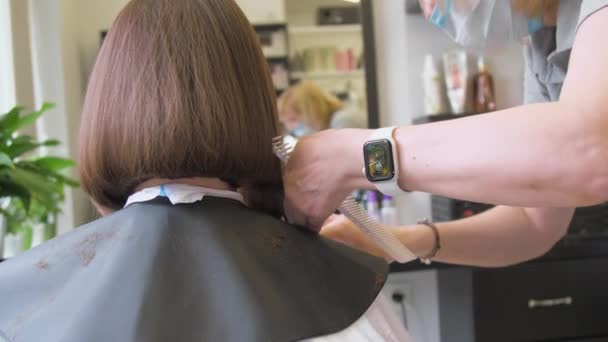 Senhora qualificada em máscara faz tiro moderno penteado escuro — Vídeo de Stock