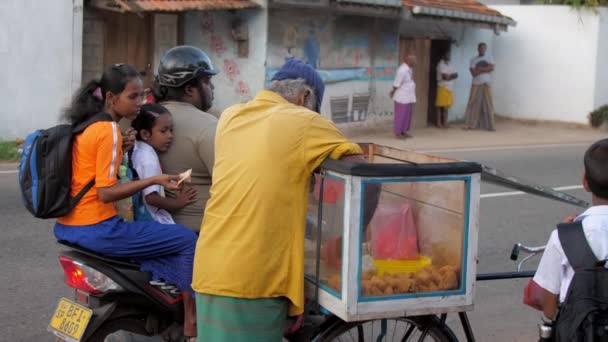 Femme et fille assis sur la moto et acheter de la nourriture traditionnelle — Video