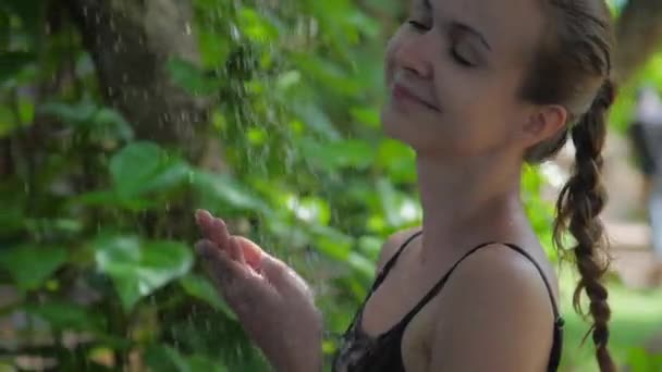 Dívka chytí kapky vody a užívá si dovolenou v tropech — Stock video