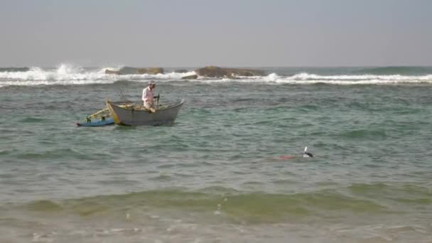 Man stands in hand made boat and sails across waving sea — Stock Video