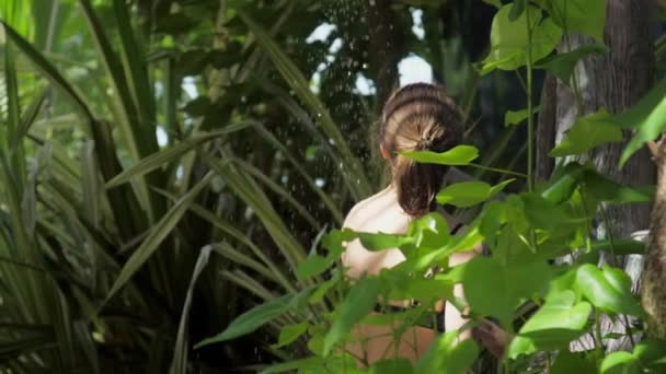 Jovem senhora concurso relaxa sob o chuveiro floresta tropical — Vídeo de Stock