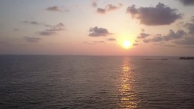 Parlak akşam güneşi sonsuz okyanus suyuna yansıyor.