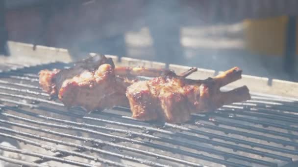 Professionel kok sætter svinekød ribben på grill gitter med tænger – Stock-video