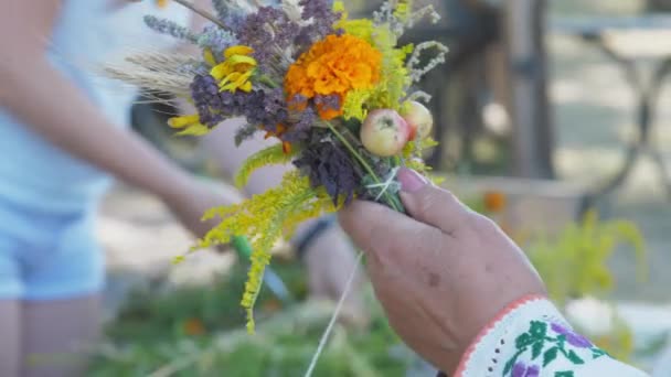 Lady hand holds traditional bouquet with white thread — Stock Video