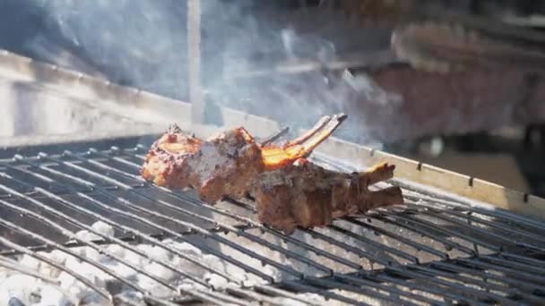 Professionel kok holder metal tang og vender svinekød ribben – Stock-video