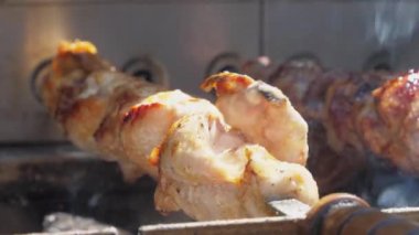 Lezzetli barbekü eti gri dumanla gümüş tükürükte döner.