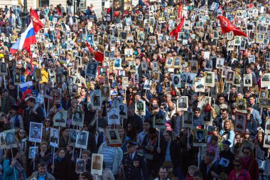 St. Petersburg, Rusya Federasyonu - 9 Mayıs 2018: insanlar onlar ölümsüz alayın Mart ayında Zafer Bayramı kutlamaları sırasında katılmak gibi tutun bayrakları ve Dünya Savaşı iki asker resimleri.