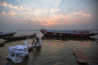 Varanasi, Hindistan - 22 Mar 2018: Adam kutsal Ganga nehrinde yaprak yıkar. Varanasi bir Hindistan en önemli hac sitelerin ve Hinduizm 7 kutsal şehirlerden biri.