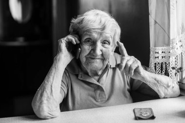 Yaşlı kadın görüşmeler üstünde hareket eden telefon.