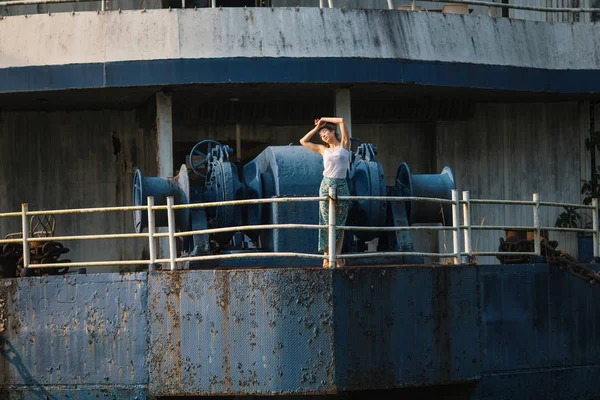 年轻美丽的混血女子在废弃的巨型金属船上 — 图库照片