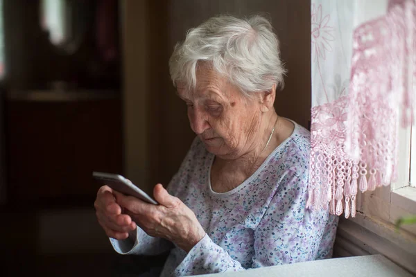 Ηλικιωμένη Γυναίκα Ένα Smartphone Στο Σπίτι — Φωτογραφία Αρχείου