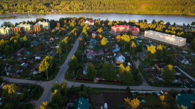 Rus köy ahşap evleriyle. Leningrad region, Rusya Federasyonu ormanların yeşil refleks nehir ve yaz. Çatılarda bir tipi kentsel yerleşim Nikolskiy uçan. 