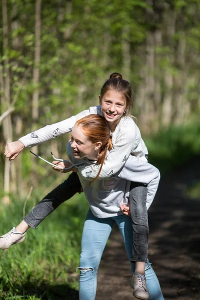 两姐妹女孩的朋友青少年骑着对方在公园里玩得开心夏天 — 图库照片