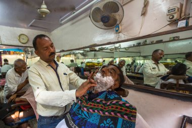 Varanasi, Hindistan - 16 Mar 2018: Kuaför Hacı saç keser. Varanasi, bir saç kesimi Hinduizm arıtma ayin bir tür olarak kabul edilir.