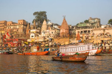 Varanasi, Hindistan - 26 Mar 2018: Bir tekne görünümünden suda Varanasi kıyı boyunca Ganj Nehri üzerinde süzülüyor. Efsaneye göre şehrin yaklaşık 5000 yıl önce Tanrı Shiva tarafından kuruldu.