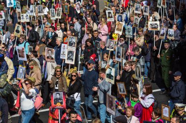 St. Petersburg, Rusya Federasyonu - 9 Mayıs 2018: insanlar onlar ölümsüz alayın Mart ayında Zafer Bayramı kutlamaları sırasında katılmak gibi tutun bayrakları ve Dünya Savaşı iki asker resimleri.