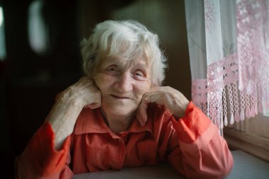 Masada oturan evde yaşlı bir kadın.