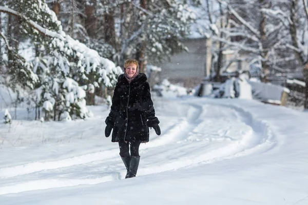 Woman in the snowy russian village at winter.