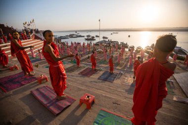 Varanasi, Hindistan - 18 Mar 2018: Genç hindu Rahipler şafak Ganj kıyısında karşılamak için bir tören yapmak ve Hint ve bayrağını yükseltmek. Varanasi Hinduizm 7 kutsal şehirlerden biri. 
