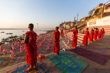 Varanasi, Hindistan - 18 Mar 2018: Genç hindu Rahipler şafak Ganj kıyısında karşılamak için bir tören yapmak ve Hint ve bayrağını yükseltmek. Varanasi Hinduizm 7 kutsal şehirlerden biri. 
