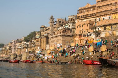 Varanasi, Hindistan - 26 Mar 2018: Bir tekne görünümünden suda Varanasi kıyı boyunca Ganj Nehri üzerinde süzülüyor. Efsaneye göre şehrin yaklaşık 5000 yıl önce Tanrı Shiva tarafından kuruldu.
