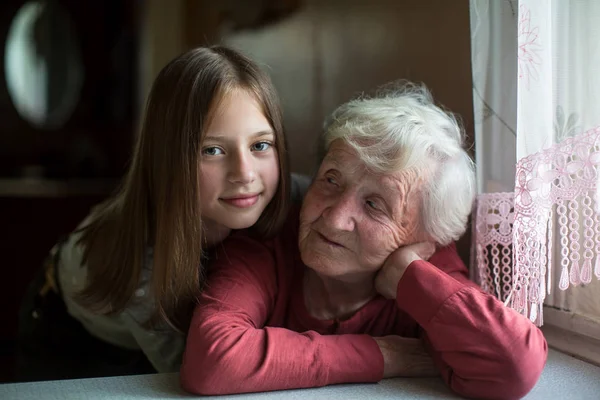 Liten Flicka Kramar Äldre Mormor För Ett Foto — Stockfoto