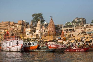 Varanasi, Hindistan - 26 Mar 2018: Bir tekne görünümünden suda Varanasi kıyı boyunca Ganj Nehri üzerinde süzülüyor. Efsaneye göre şehrin yaklaşık 5000 yıl önce Tanrı Shiva tarafından kuruldu.